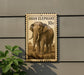a large stamp-like sign with an illustration of an elephant, mounted on a wall.