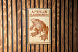 a sign with an illustration of an African clawed frog.