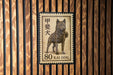 A postage stamp featuring a dog, specifically a kai dog, which is a breed of dog native to Japan.