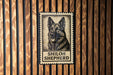 A metal sign featuring a black and white illustration of a German Shepherd dog with the text "SHILOH SHEPHERD" below it.
