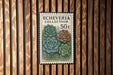 a postage stamp with a floral design, placed on a wooden wall.