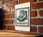 A sign with a graphic of hiking boots mounted on a brick wall.