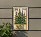 A metal sign with a postage stamp design, featuring a plant illustration and the text "SAGE PATCH" on a wall.