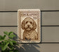 A sign featuring a dog's portrait, resembling a postage stamp, mounted on a wall.