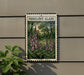 a framed illustration of pink flowers on a wall, with the text "FOXGLOVE GLADE" above the flowers.