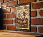 A metal sign with a vintage-style illustration of garlic bulbs mounted on a brick wall.