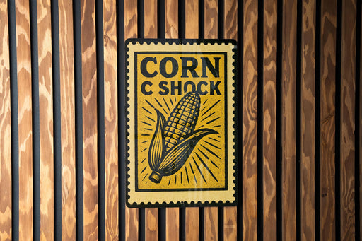a sign with the text "CORN C SHOCK" and an illustration of a corn cob.