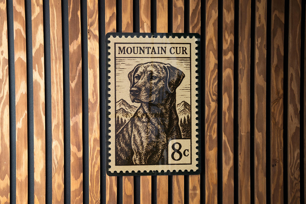 A metal plate with a printed image of a dog, resembling a postage stamp, mounted on a wooden wall.