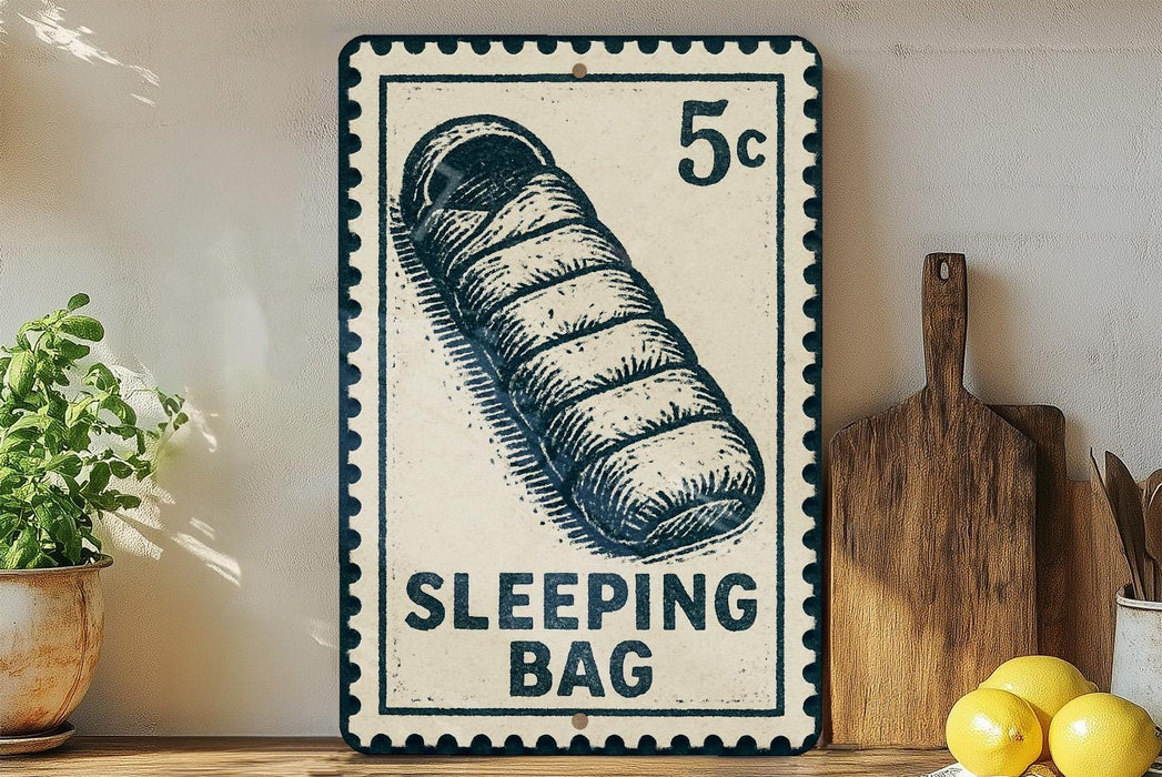 A vintage-style metal sign with a sleeping bag illustration, placed on a wooden surface next to a wooden cutting board and some lemons.
