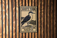 A sign for the Sooty Tern, a species of seabird, mounted on a wooden wall.