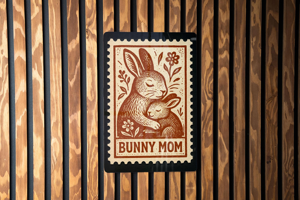 A brown and white stamp-like design featuring a mother rabbit and her baby, with the text "BUNNY MOM" below the illustration.