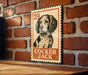 A metal sign featuring a black and white illustration of a cocker jack dog, mounted on a brick wall.