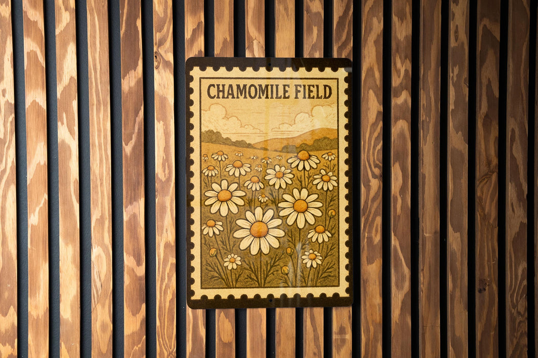 a framed poster of a field of flowers, specifically chamomile flowers, hanging on a wooden wall.