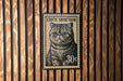 A black and white cat stamp with the text "Exotic Shorthair" and the denomination "30¢" is displayed on a wooden wall.