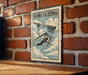 A vintage-style metal sign with the text "HANG GLIDING" and an illustration of a person hang gliding against a brick wall.