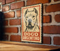 A sign featuring a dog's face on a brick wall.
