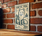 A wooden table with a framed image of a white fox on it, mounted on a brick wall.