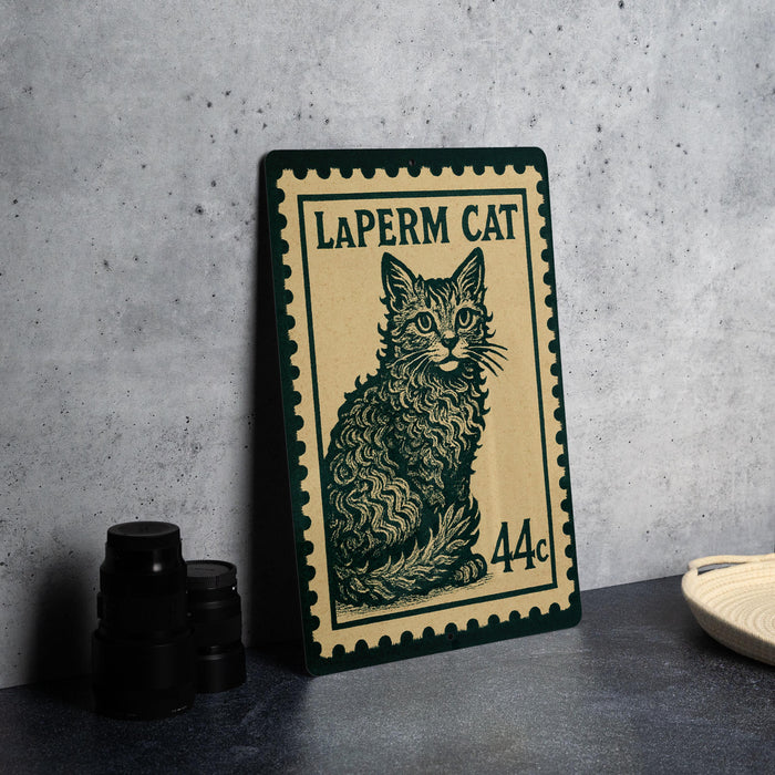 A framed image of a cat, resembling a postage stamp, is displayed on a table next to some black camera lenses.