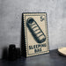A sleeping bag postage stamp on a table, with a stack of black camera lenses next to it.