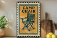 a sign that reads "Camp Chair" with a picture of a folding chair on it. The sign is placed on a shelf next to a wooden cutting board and a potted plant.