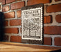 a wooden sign with a brick wall in the background.