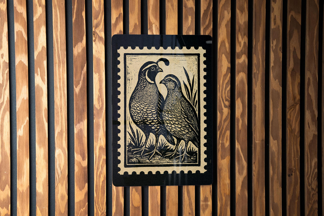 a pair of quails, a type of bird, depicted in a woodcut-style illustration on a black and white background.