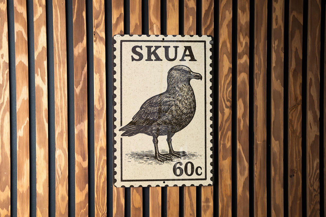 A postage stamp featuring a bird, likely a seagull, is displayed on a wooden wall.