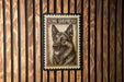 A framed image of a King Shepherd dog is displayed on a wooden wall.