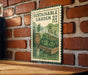 A vintage-style metal sign with a garden illustration and text, mounted on a brick wall.