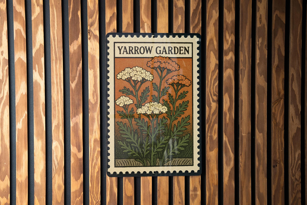 A vintage-style postage stamp featuring a floral illustration is displayed on a wooden wall.