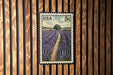 A U.S. postage stamp depicting a field of lavender flowers, with a path leading through the field.