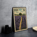 A framed postage stamp depicting a field of lavender flowers, with a road leading through the scene.
