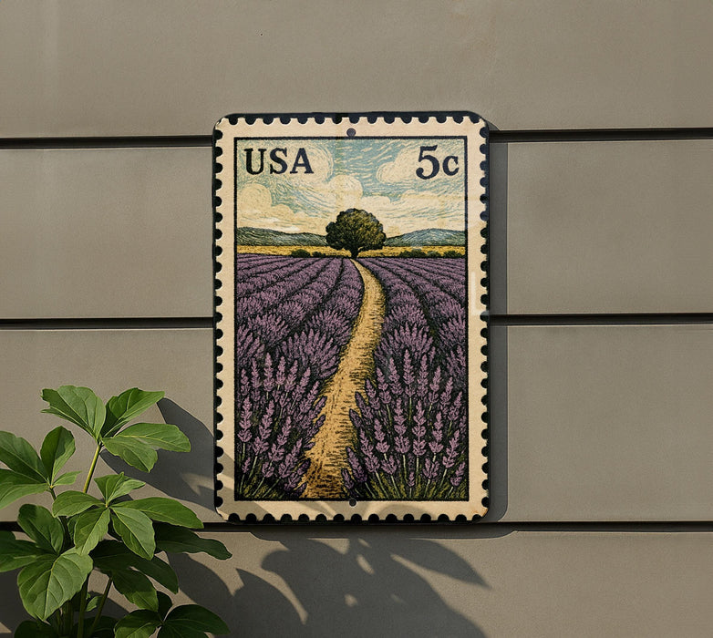 A framed postage stamp depicting a field of lavender flowers, with a tree in the background, is mounted on a wall.