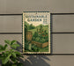A metal sign with a garden scene and gardening tools, mounted on a wall.