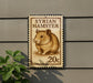 A postage stamp featuring a hamster is displayed on a wall, with a plant visible to the left.