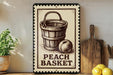 A vintage-style metal sign with a wooden bucket and a peach on it, placed on a wooden shelf next to a wooden cutting board and some lemons.