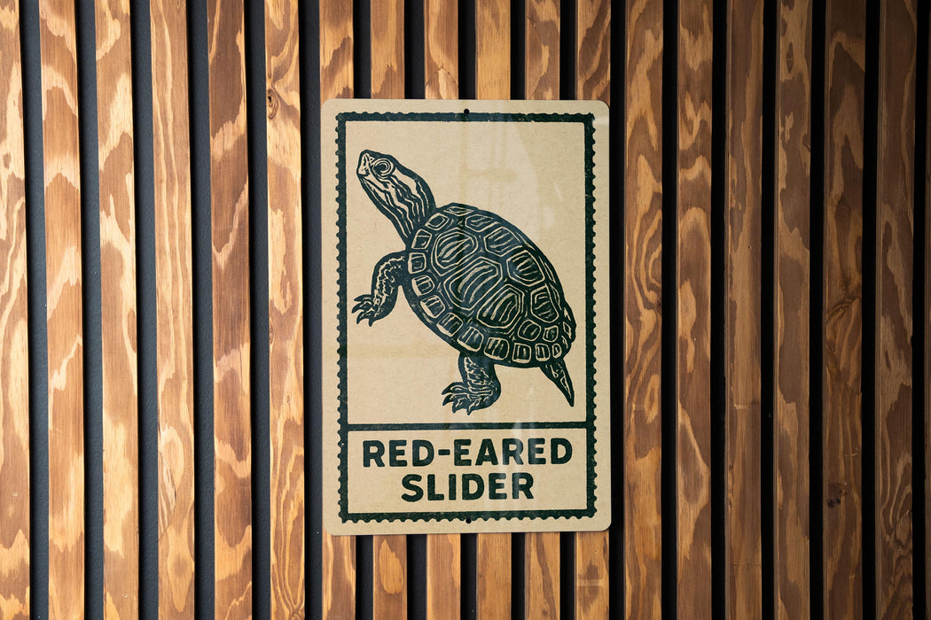 A sign with a turtle illustration and the text "RED-EARED SLIDER" is displayed on a wooden wall.