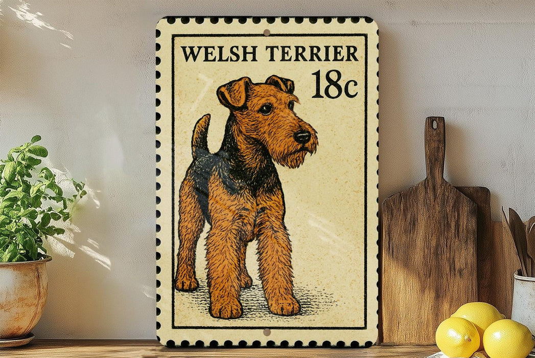 A Welsh terrier dog is depicted on a postage stamp-like sign, which is placed on a wooden surface next to a potted plant and a wooden cutting board.