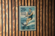 A vintage-style metal sign with a water skiing illustration, mounted on a wooden wall.