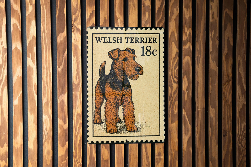 A Welsh terrier dog is depicted on a postage stamp-like sign, which is mounted on a wooden wall.