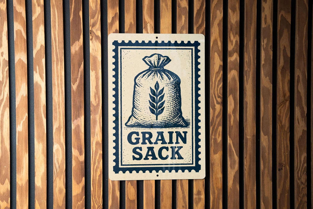 A metal sign with a graphic of a bag of grain and the text "GRAIN SACK" is displayed on a wooden wall.