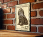 A metal sign with a printed image of a Field Spaniel dog, mounted on a brick wall.