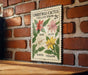 a Christmas Cactus stamp with illustrations of red, pink, white, and yellow flowers, displayed on a brick wall.