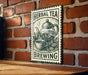 A sign for "Herbal Tea Brewing" is displayed on a brick wall, featuring an illustration of a teapot and a cup of tea.
