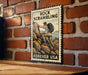 A vintage-style metal sign with a mountain landscape and a person climbing on rocks, mounted on a brick wall.