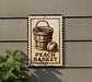 A sign on a wall that reads "Peach Basket" with an illustration of a wooden bucket and an apple.