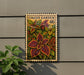 A decorative postage stamp featuring a vibrant plant with large leaves, mounted on a wall next to a potted plant.