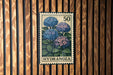 A vintage-style postage stamp from Hydrangea, featuring a floral illustration of blue hydrangea flowers.