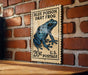 A vintage-style postage stamp featuring a blue poison dart frog, mounted on a brick wall.