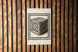 a wooden wall with a sign featuring a wooden crate or box illustration.